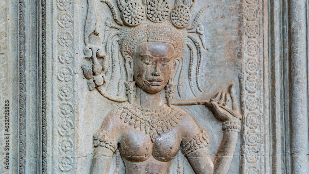Wall carving with womans dancers apsara. Ancient ruins Angkor Wat temple - famous Cambodian landmark. Siem Reap, Cambodia.