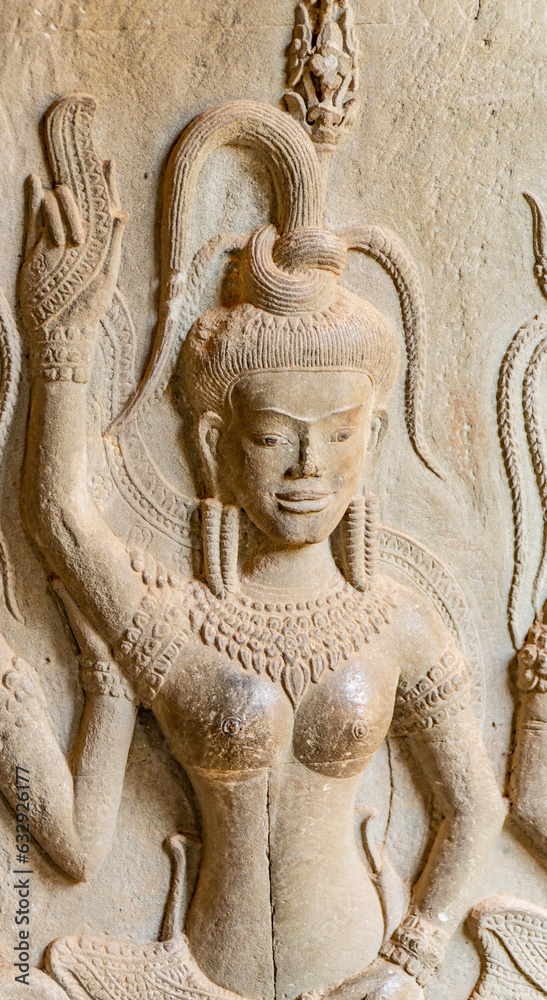 Wall carving with womans dancers apsara. Ancient ruins Angkor Wat temple - famous Cambodian landmark. Siem Reap, Cambodia.