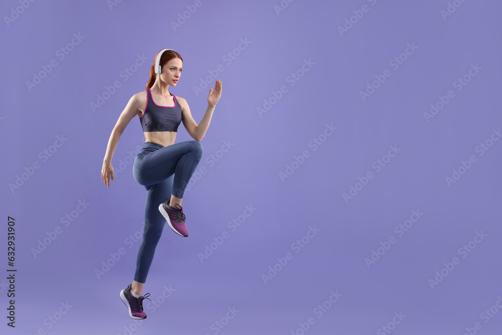 Woman in sportswear running on violet background, space for text
