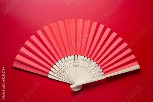 Chinese folding fan on red background
