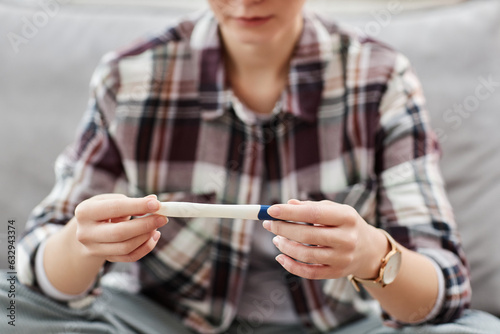 Close up of unrecognizable young woman holding pregnancy test waiting for result  copy space