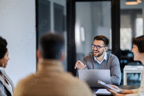 A multiracial team is sitting at the boardroom and having briefing at the corporate company.