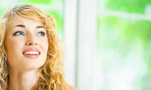Portrait of happy cheerful smiling young beautiful blond woman, indoors