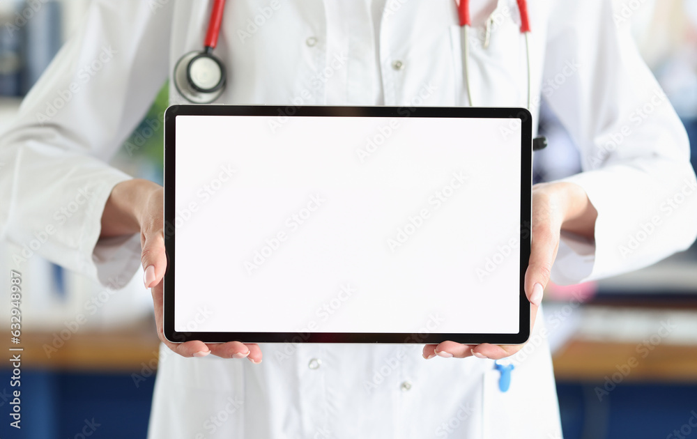 Doctor holds tablet with white screen in medical office. Choosing medical profession concept Doctor holds tablet with white screen in medical office. Choosing medical profession concept