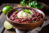 Red beans and rice topped with fresh cilantro and a slice of lime, a colorful close-up on a rustic wooden table.