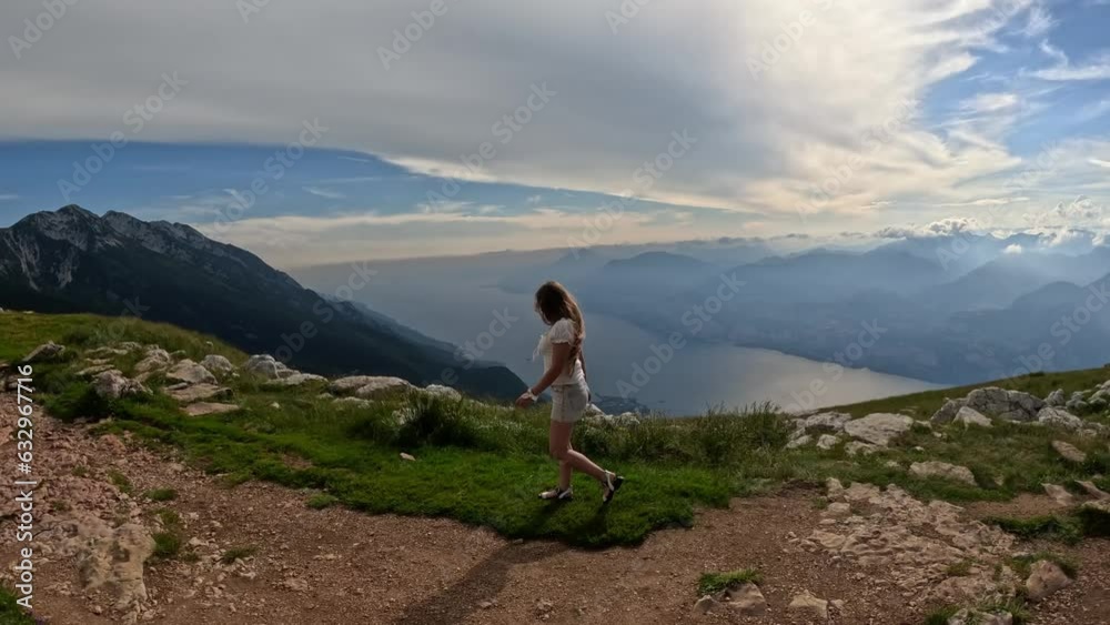 Woman walks above Garda lake. Timelapse Woman walks above Garda lake. Timelapse