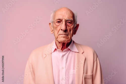 Medium shot portrait photography of a man in his 80s with a pained and tired expression due to fibromyalgia wearing a chic cardigan against a pastel or soft colors background 