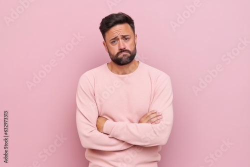 Medium shot portrait photography of a man in his 30s appearing tired and down due to hypothyroidism wearing a pair of leggings or tights against a pastel or soft colors background  © Leon Waltz