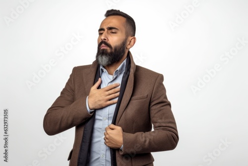 Medium shot portrait photography of a man in his 30s coughing with discomfort due to pneumonia wearing a chic cardigan against a white background 