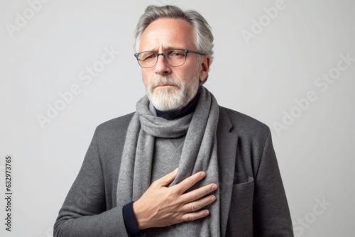 Medium shot portrait photography of a man in his 50s coughing with discomfort due to pneumonia wearing a chic cardigan against a white background  © Leon Waltz