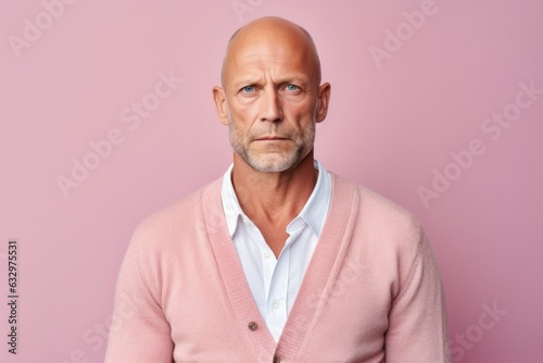 Medium shot portrait photography of a man in his 40s showing tiredness and a worn-down expression due to chronic fatigue syndrome wearing a chic cardigan against a pastel or soft colors background 