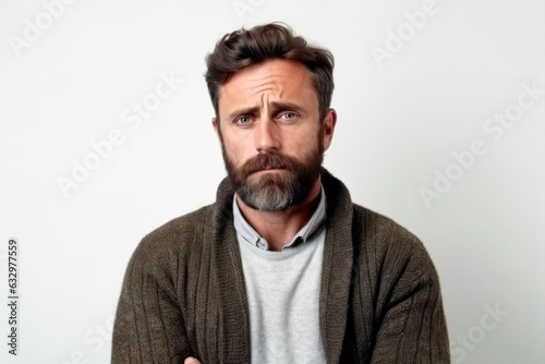 Medium shot portrait photography of a man in his 30s with a somber and deeply sad expression due to major depression wearing a chic cardigan against a white background  © Leon Waltz