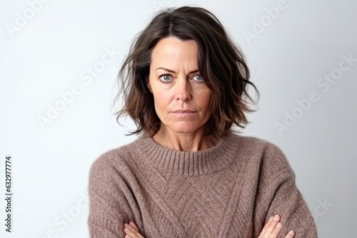 Medium shot portrait photography of a woman in her 40s with a somber and deeply sad expression due to major depression wearing a cozy sweater against a white background 