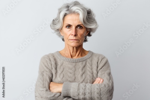 Medium shot portrait photography of a woman in her 50s with a somber and deeply sad expression due to major depression wearing a cozy sweater against a white background 