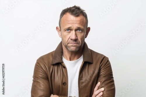 Lifestyle portrait photography of a man in his 40s looking anxious and fidgety due to generalized anxiety disorder wearing a chic cardigan against a white background  © Leon Waltz