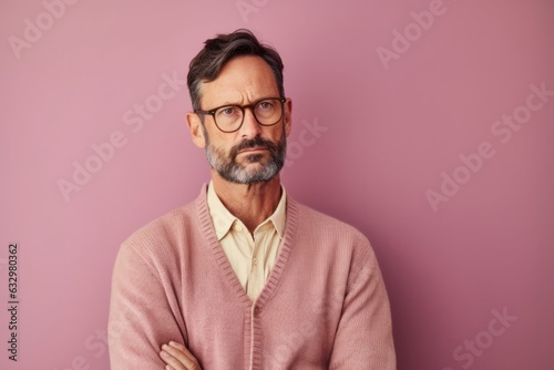Lifestyle portrait photography of a man in his 40s looking anxious and fidgety due to generalized anxiety disorder wearing a chic cardigan against a pastel or soft colors background 