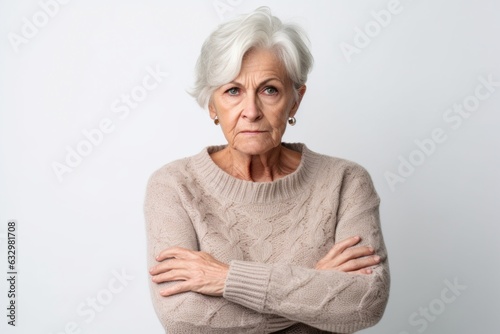 Group portrait photography of a woman in her 70s visibly in discomfort and fatigue from an autoimmune disease like lupus wearing a cozy sweater against a white background 