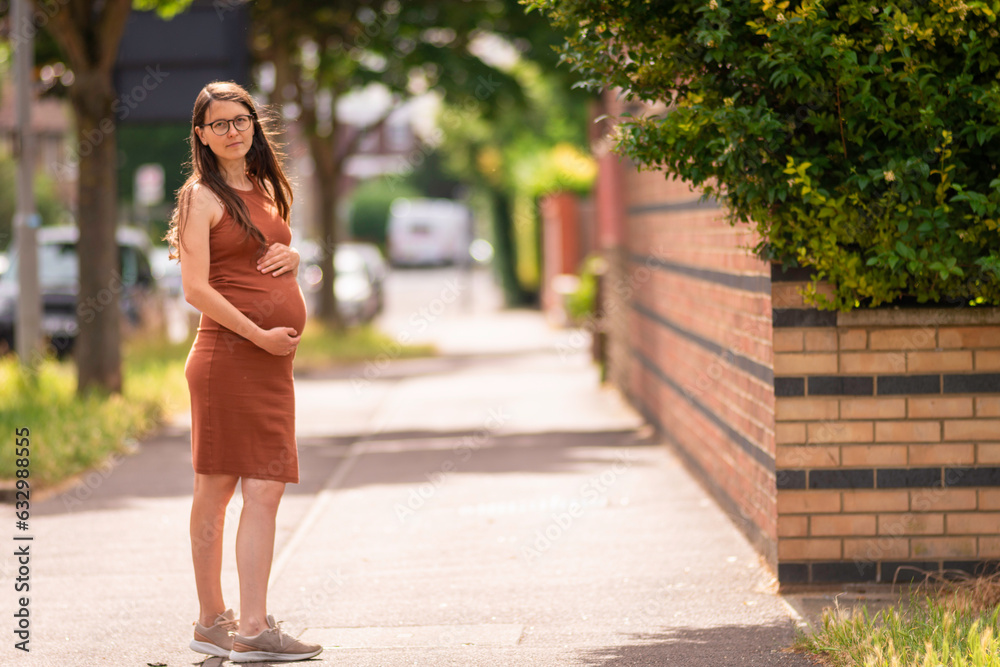 Beautiful young pregnant woman belly london smiling confident  city street outdoors walk urban cityscape 9 months smiling Active mom Brunet caucasian  summer glasses brown Tight dress Tummy