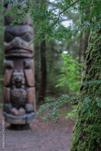 Tlingit totem poles and lush woods tree nature landscape scenery in Sitka Historical Park hiking trails with creeks, green bushes and vegetation in magic fairytale environment Baranof Island photo