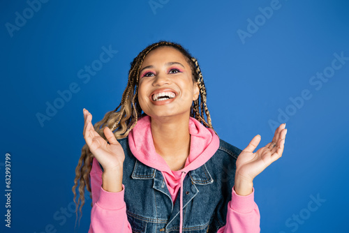 Canvas-taulu happy african american woman with dreadlocks laughing and gesturing on blue back