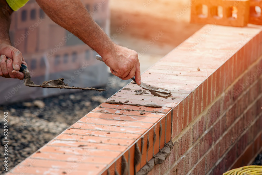 Close up of a brick wall and jointer trowel used by the worker to apply