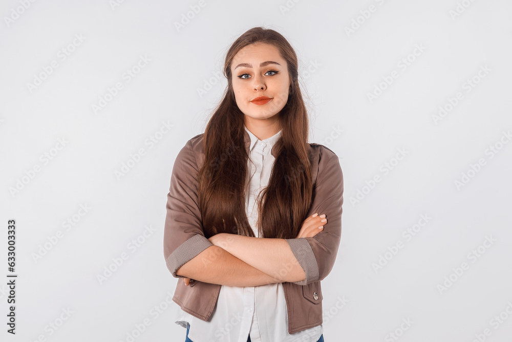 Portrait of displeased offended girl with dark hair, keeps arms folded, looks angrily to the camera, doesn't agree with somebody's opinion. Studio shot, white background Portrait of displeased offended girl with dark hair, keeps arms folded, looks angrily to the camera, doesn't agree with somebody's opinion. Studio shot, white background