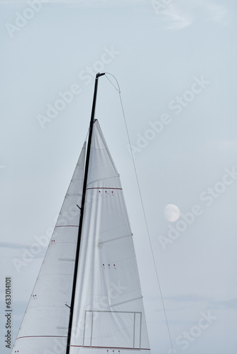 sail of sailing boat at full moon, black mast