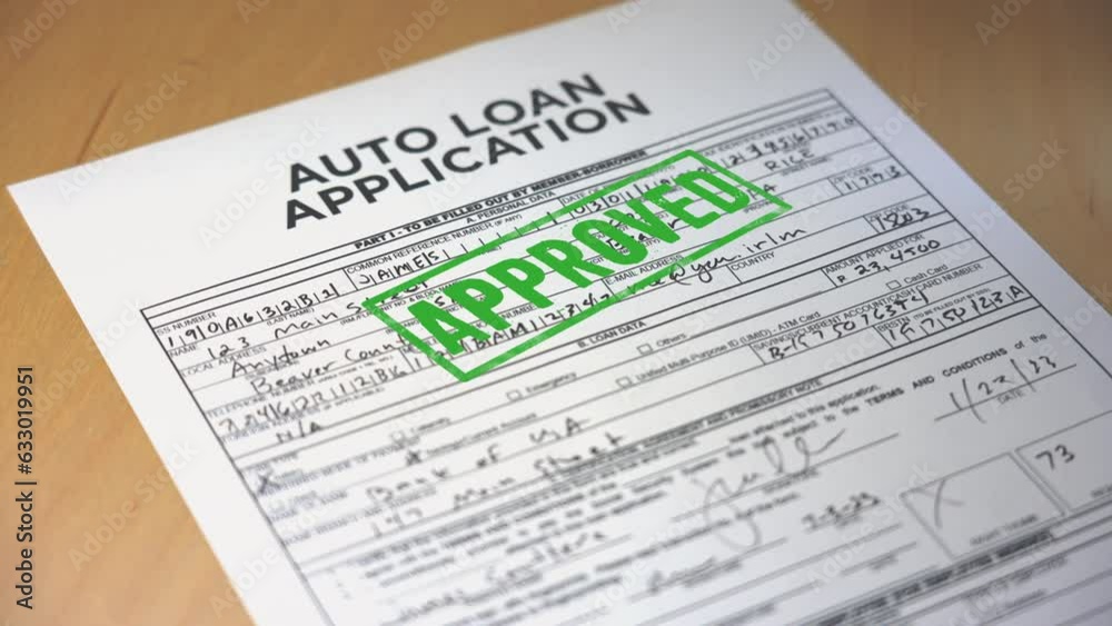 A closeup view of a automobile loan application getting approved. Data on form is fictional.  	