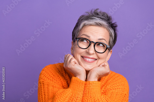 Photo of sweet dreamy lady wear knitted pullover spectacles arms cheeks looking empty space isolated purple color background