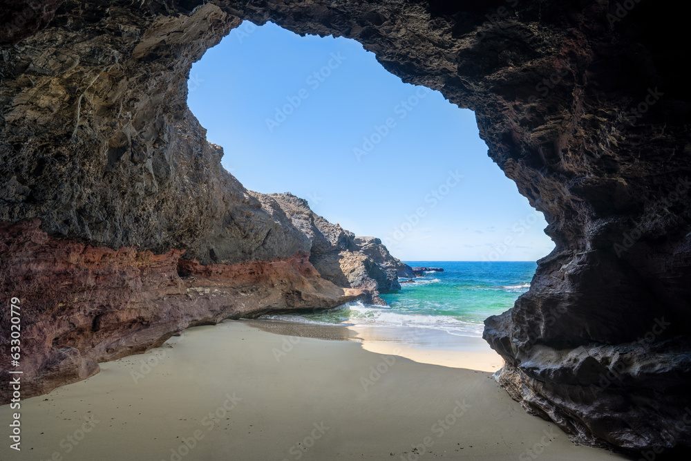 Höhle Cueva de Playa de los Ojos an der Südspitze von Fuerteventura - Blick aus der Höhle auf die Felsenküste und das Meer bei Ebbe