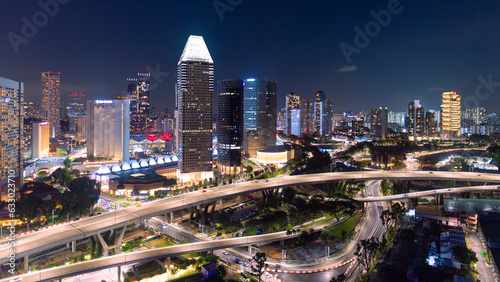 Panorama of Singapore's business district at night  showing a skyscraper building area and a road. © ChomchoeiFoto