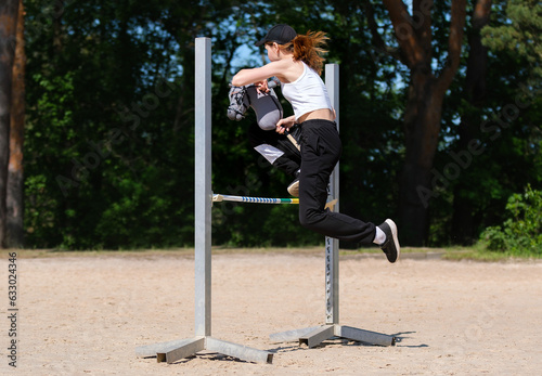 Girl jumping on hobby horse. Champion. Horse sport. Summer light. Green outdoor trees background. The Cavaletti route. Child sport. Banner