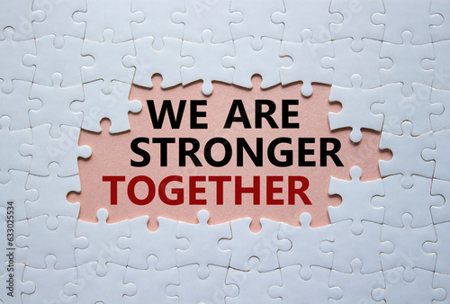 We are stronger together symbol. White puzzle with words We are stronger together. Beautiful pink background. We are stronger together concept. Copy space. photo