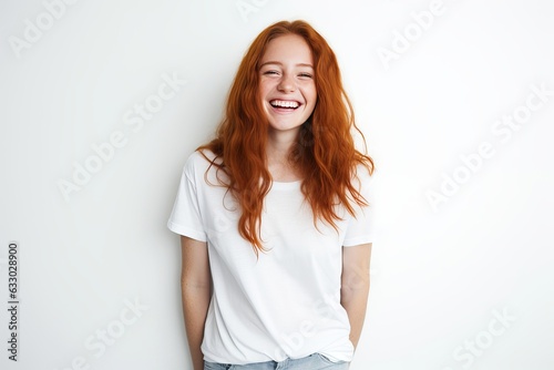 Natural happy woman with long red ginger hair, laughing carefree, con half of face with hand and smiling cheerful, standing in t-shirt, positive face expression on white background