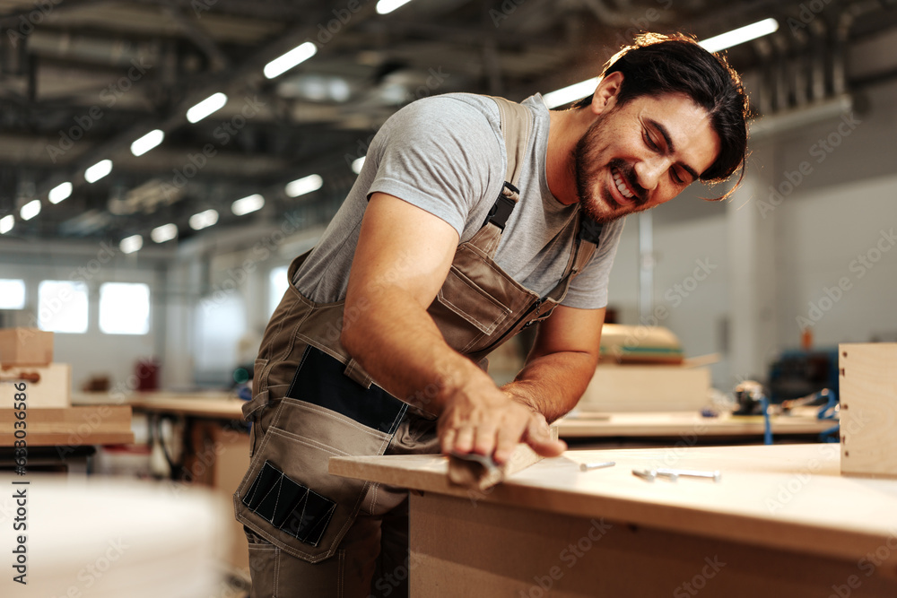 Young carpenter making wood furniture while working in joinery Young carpenter making wood furniture while working in joinery