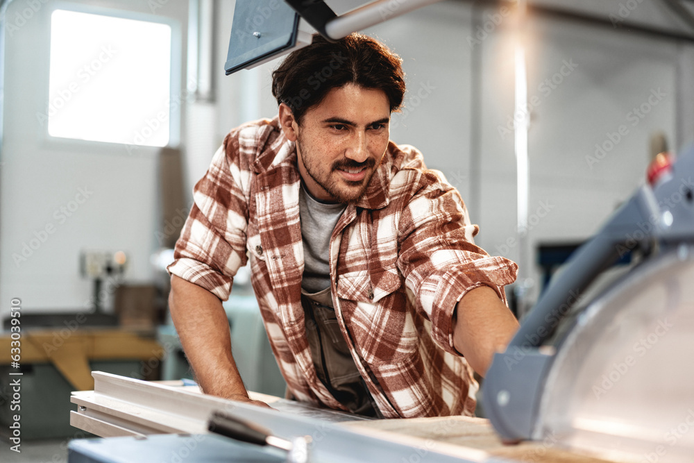 Male carpenter using some woodworking tools for his work in a factory Male carpenter using some woodworking tools for his work in a factory