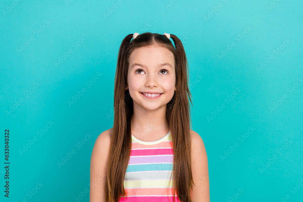 Photo of cute small adorable school girl look up empty space mockup read information isolated aquamarine color background Photo of cute small adorable school girl look up empty space mockup read information isolated aquamarine color background
