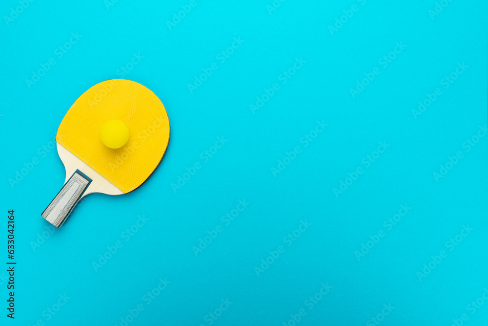 Racket and ball for table tennis on turquoise blue background. Flat lay image of table tennis paddle with a ball. Minimalist photo of yellow ping-pong equipment with copy space Racket and ball for table tennis on turquoise blue background. Flat lay image of table tennis paddle with a ball. Minimalist photo of yellow ping-pong equipment with copy space