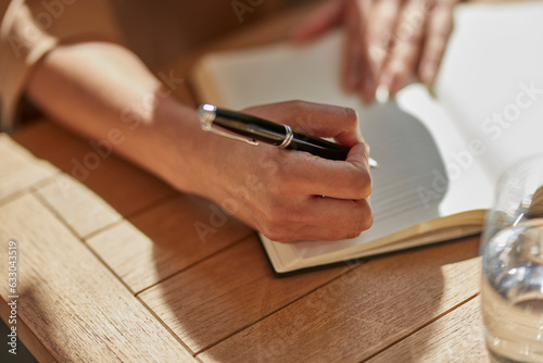 Hand of businesswoman writing notes