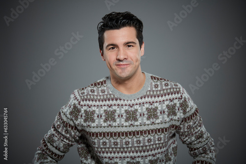 Portrait of young man wearing patterned sweater.