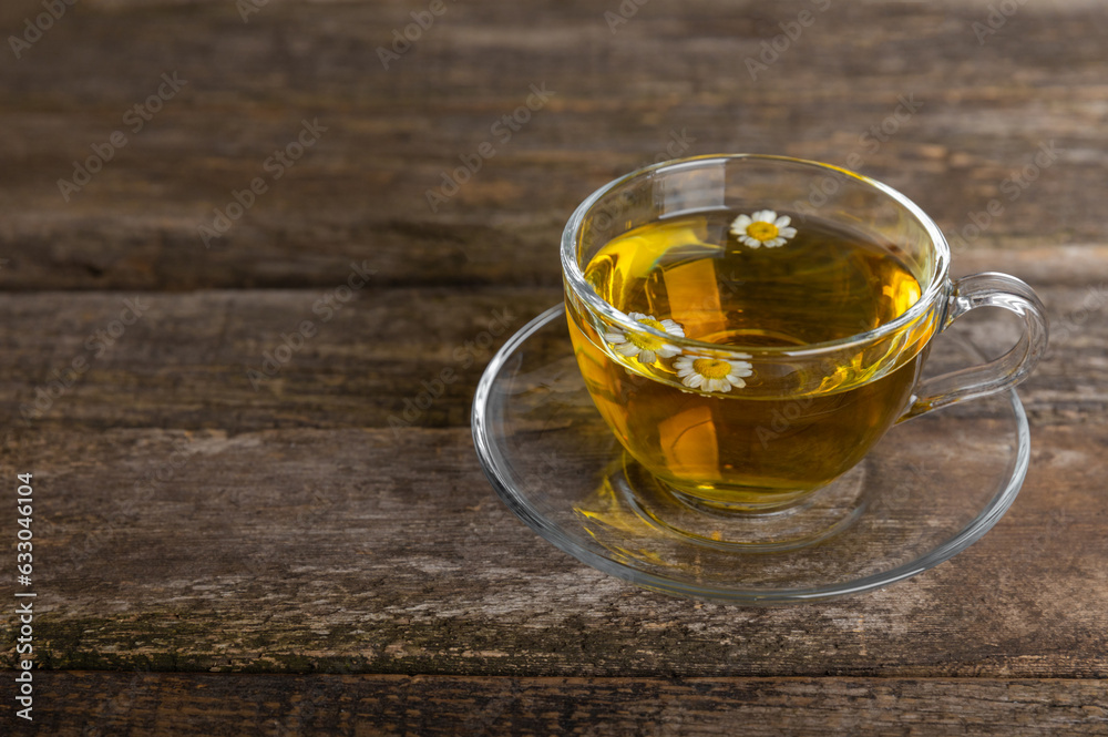 Chamomile tea on a brown table. Delicious tonic, soothing and relaxing chamomile tea with chamomile flowers, honey and lemon. Herbal tea for immunity. Close-up.Place for text.Copy space. Chamomile tea on a brown table. Delicious tonic, soothing and relaxing chamomile tea with chamomile flowers, honey and lemon. Herbal tea for immunity. Close-up.Place for text.Copy space.
