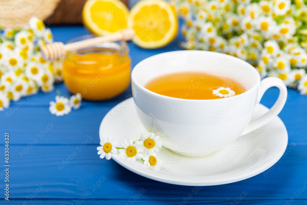 Chamomile tea on a blue table. Delicious tonic, soothing and relaxing chamomile tea with chamomile flowers, honey and lemon. Herbal tea for immunity. Close-up.Place for text.Copy space. Chamomile tea on a blue table. Delicious tonic, soothing and relaxing chamomile tea with chamomile flowers, honey and lemon. Herbal tea for immunity. Close-up.Place for text.Copy space.