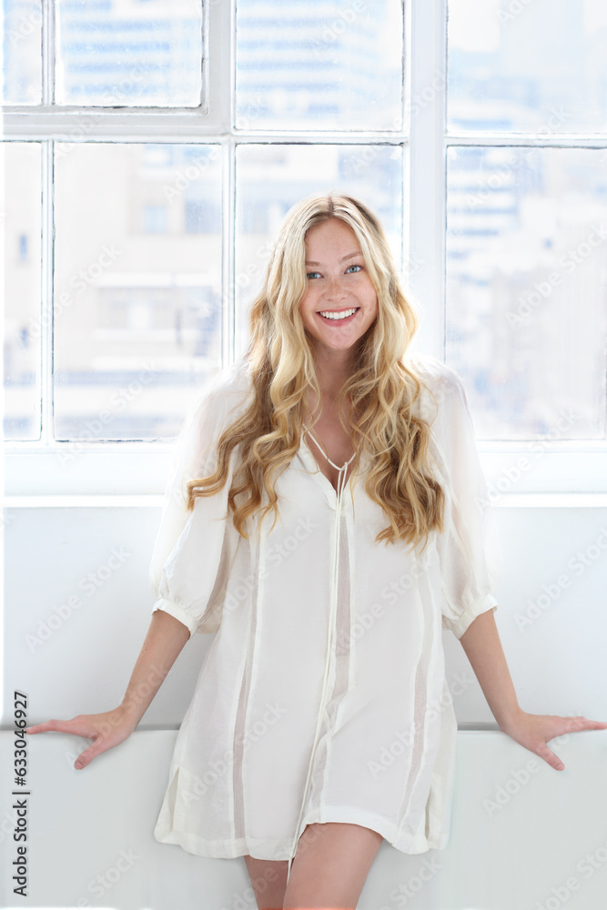 Portrait of young woman with blonde hair wearing white tunic. Portrait of young woman with blonde hair wearing white tunic.