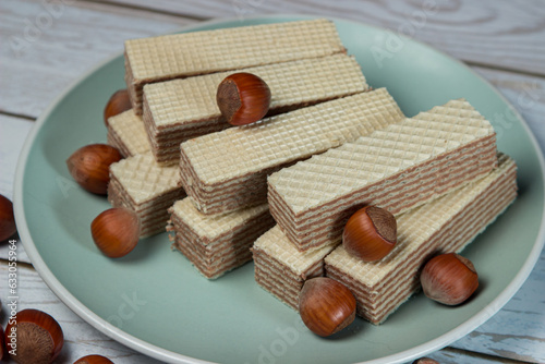 Wafers with nut filling on a plate with hazelnuts photo