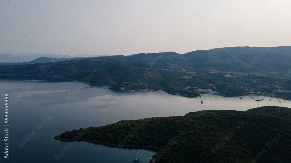 Photo shows sunrise at Greece Syvota with morning sun shinning through the old town. Photo also show the blue sea water and clear sky. Aerial view. Photo shows sunrise at Greece Syvota with morning sun shinning through the old town. Photo also show the blue sea water and clear sky. Aerial view.