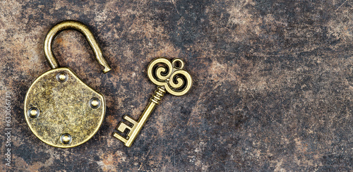 Old vintage key and padlock on a rusty grunge metal background. Escape room game banner.
