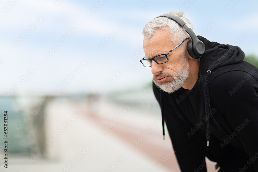 Tired senior man take break while exercising outdoor, copy space Tired senior man take break while exercising outdoor, copy space