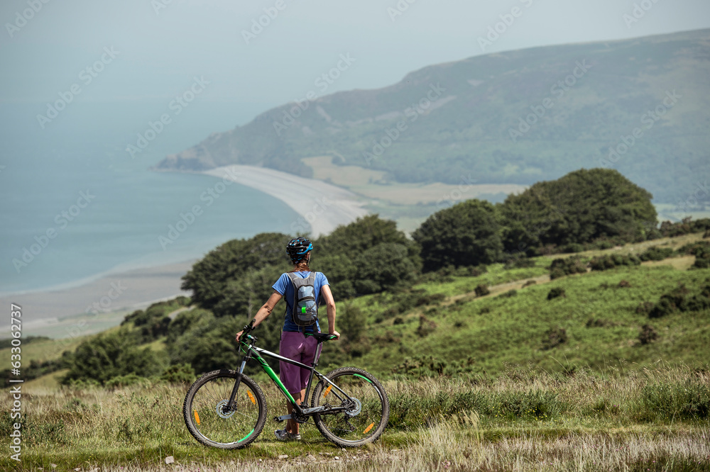 Woman with mountain bike on hill Woman with mountain bike on hill