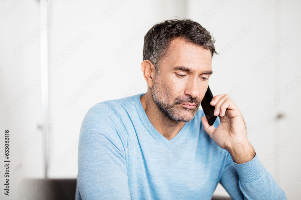 Mature businessman talking on smartphone in office Mature businessman talking on smartphone in office