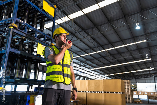 Warehouse factory worker man using handradio working in contribution warehouse photo